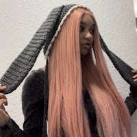 a woman with long pink hair wearing a bunny hat